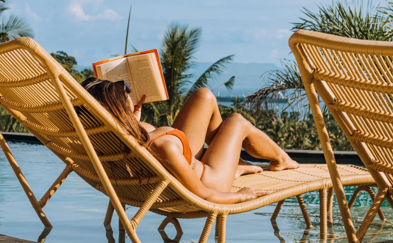 Hotel Neano Escape Manggis Esterno foto A woman reading a book on a beach